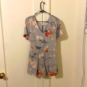 Romper that is a mix to between a dull blue/lavender with floral print